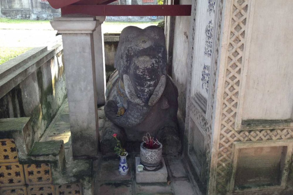 Two kneeling stone elephants guard the entrance, giving the temple its name, 'Voi Phuc’